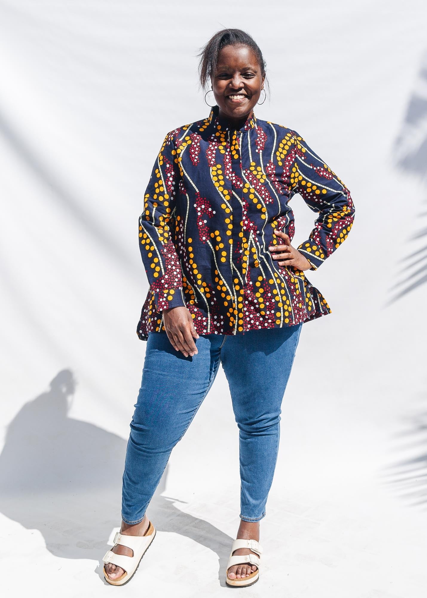 The model is wearing navy, yellow, white, red print shirt