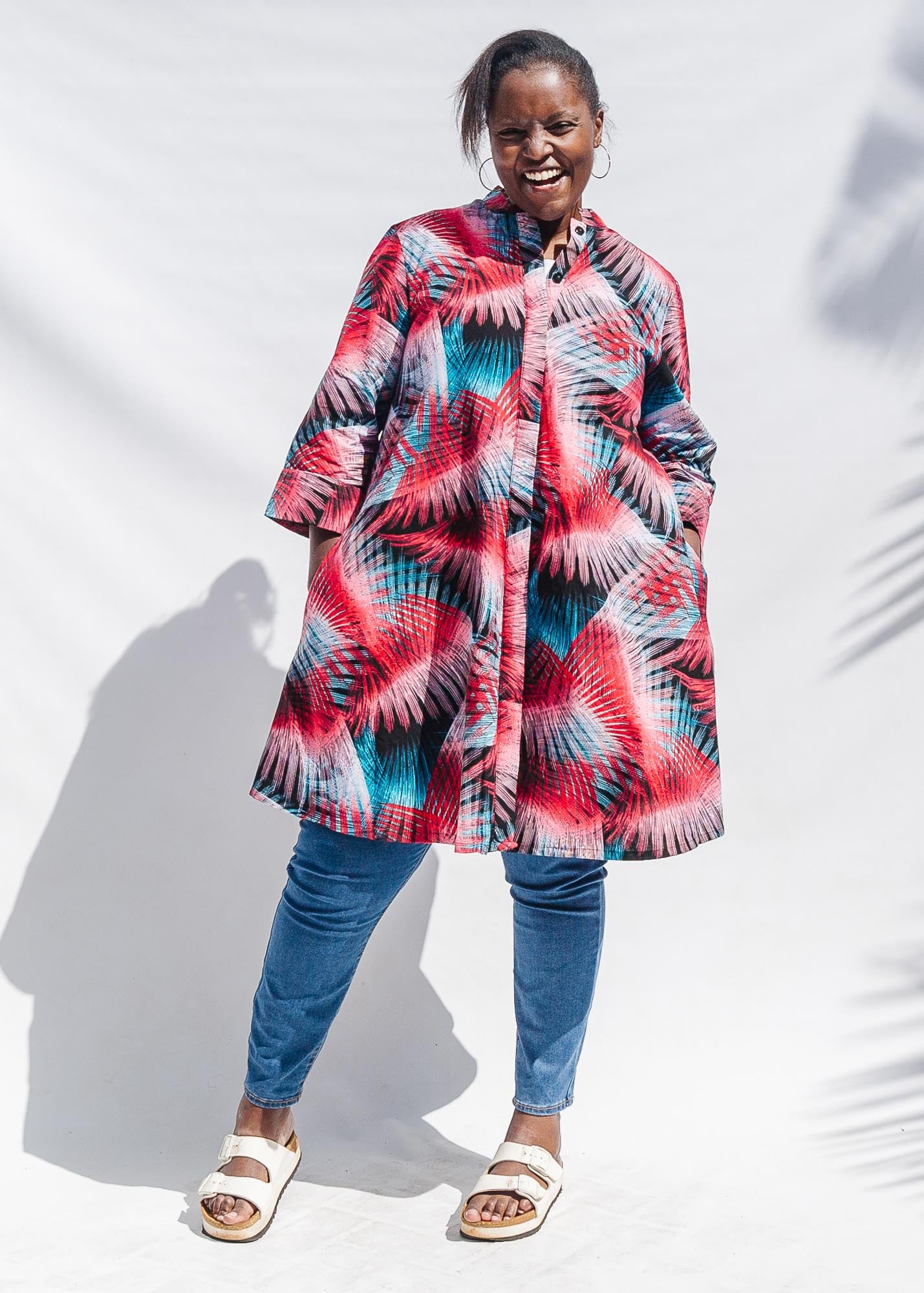 The model is wearing black, red, pink, light blue print dress