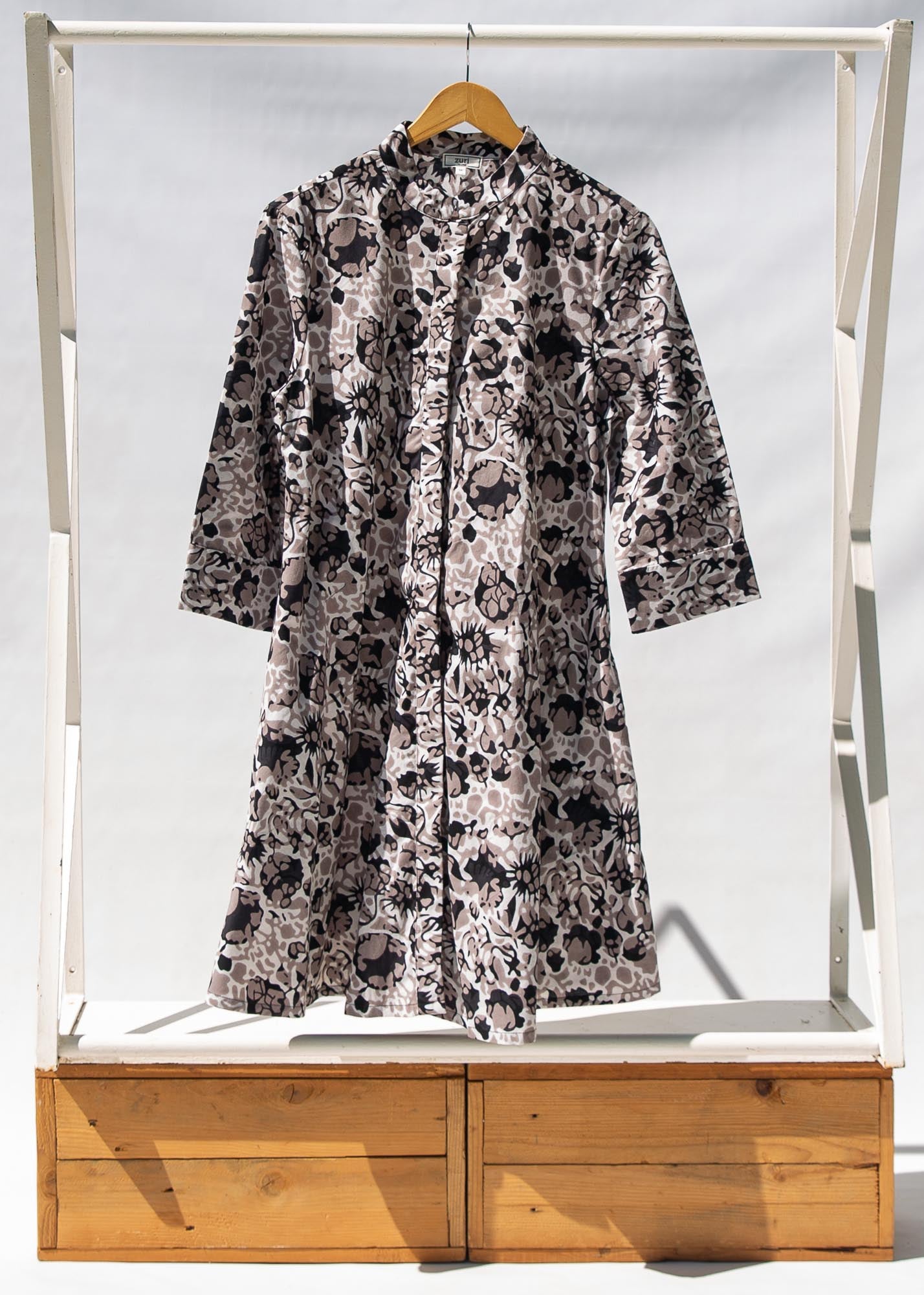 Display of black, off white, gray and dark gray abstract print dress