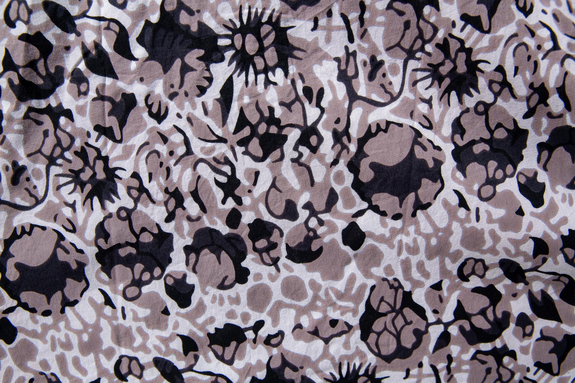 Close up display of black, off white, gray and dark gray abstract print dress