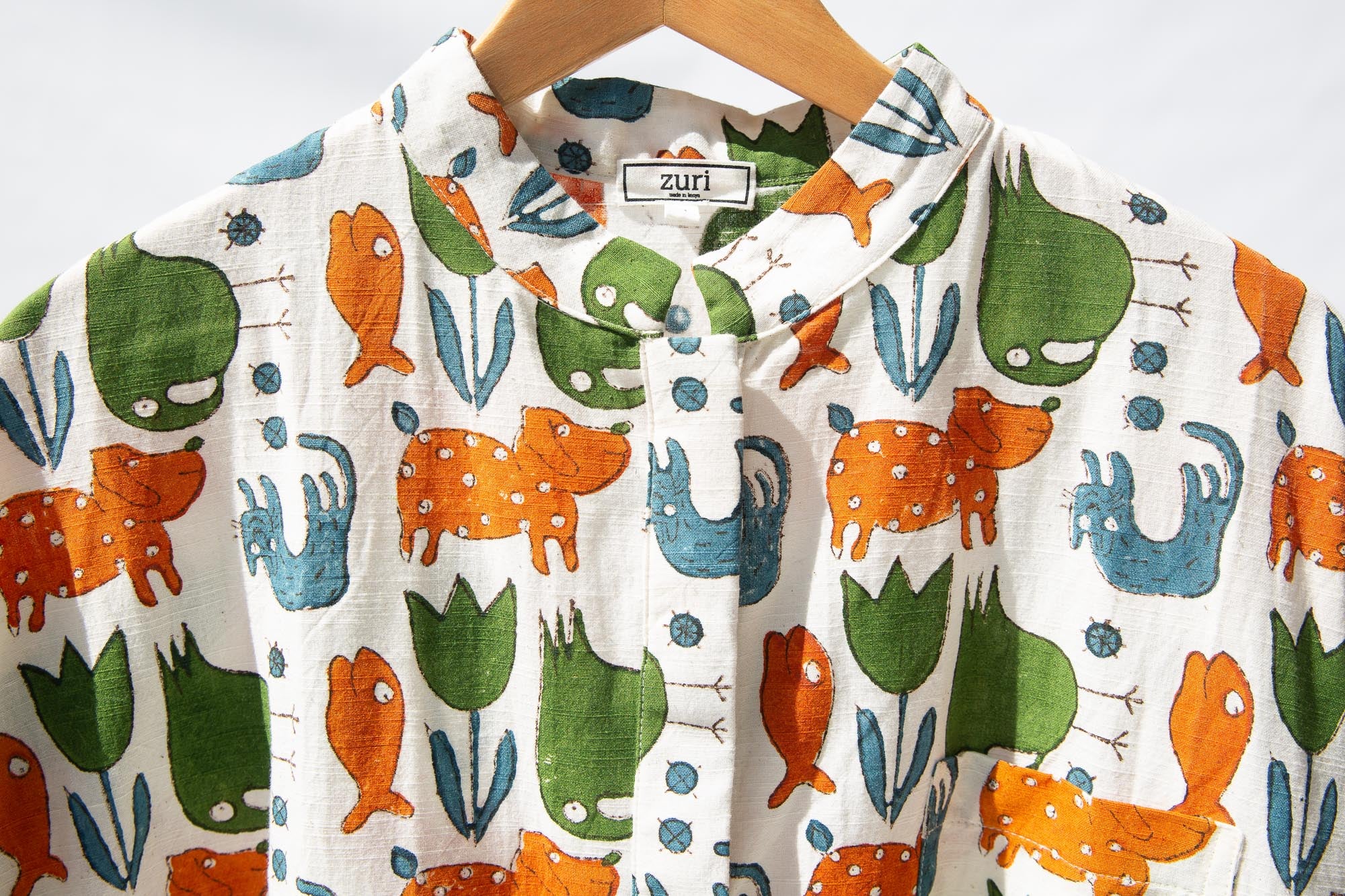 Display of blue, orange, green, brown, white and black print shirt