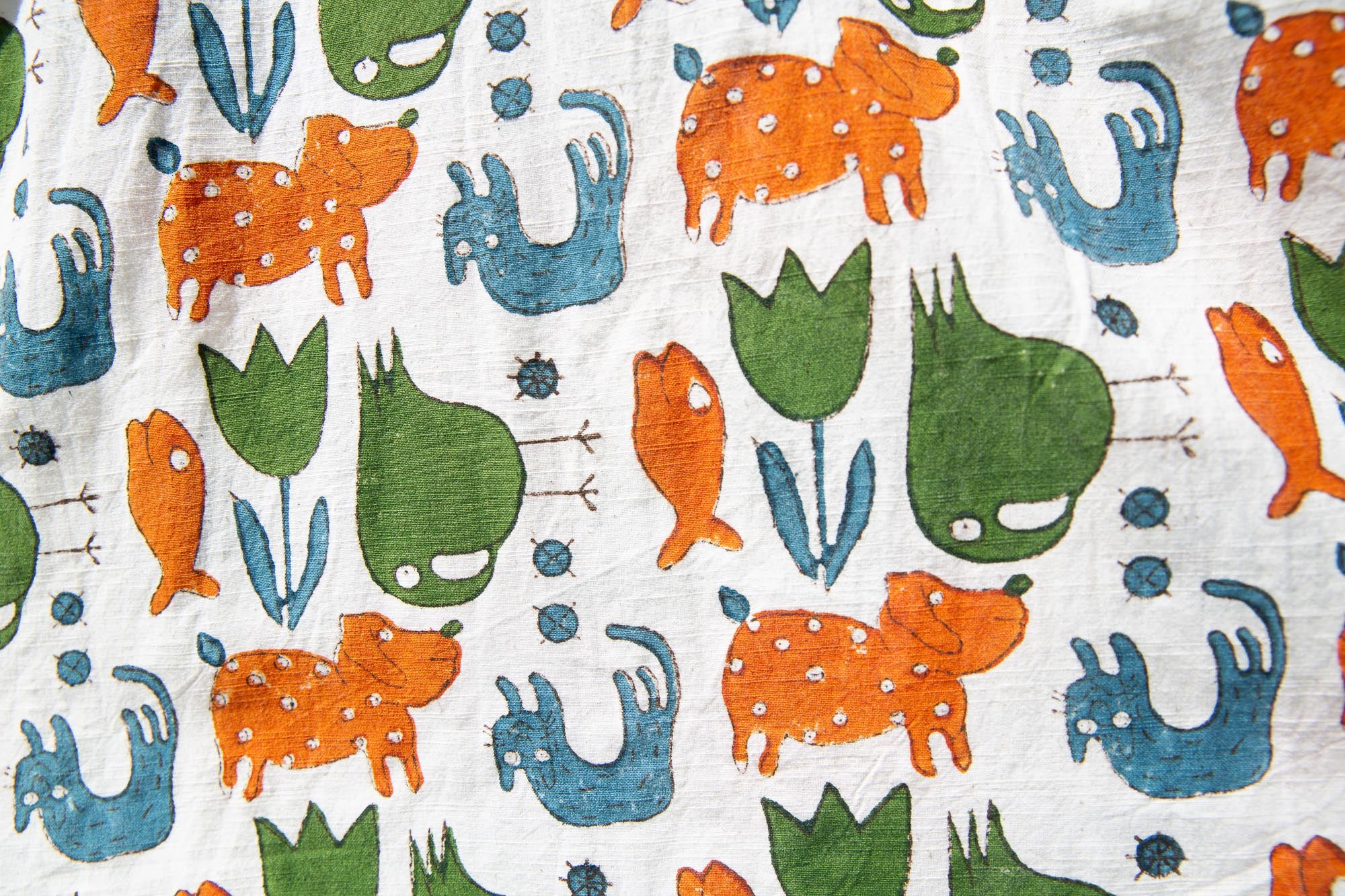 Close up display of blue, orange, green, brown, white and black print shirt