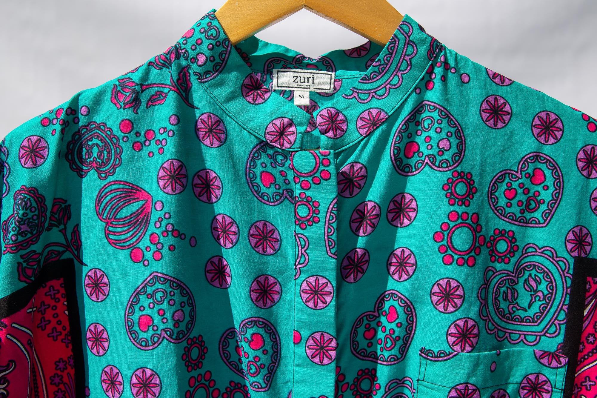 Display of black, pink, sky blue, white, purple print shirt