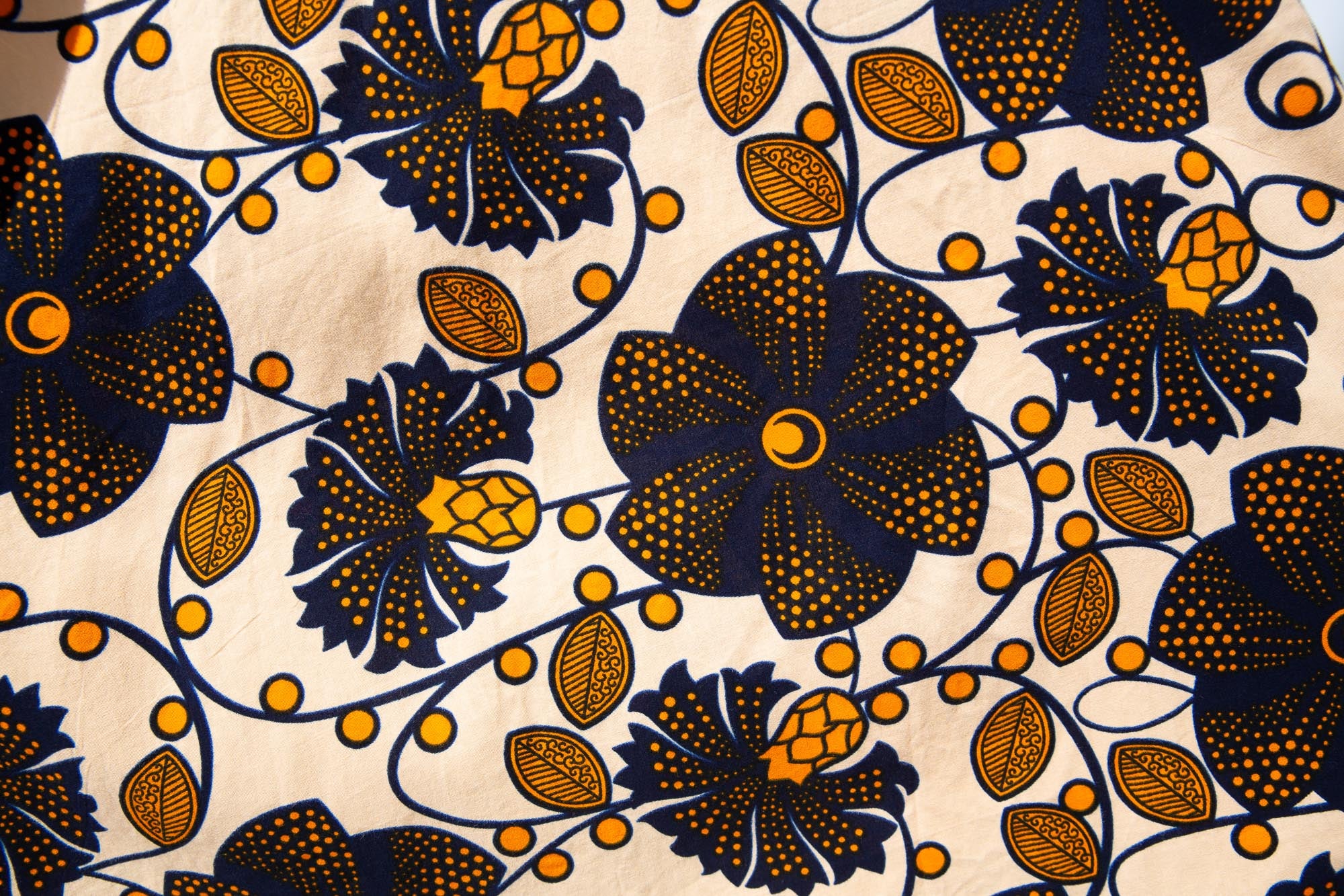 Close up display of navy, black, off white, yellow flower print dress