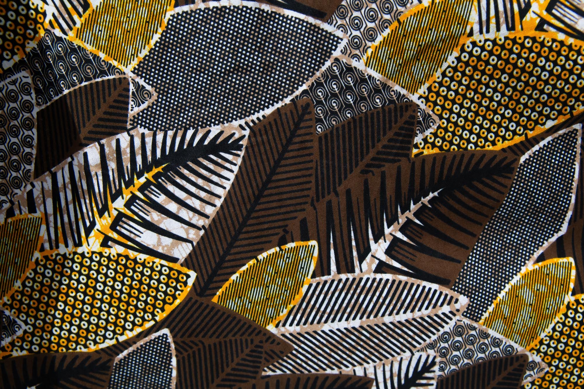 Close up display of black, brown, yellow, beige print dress