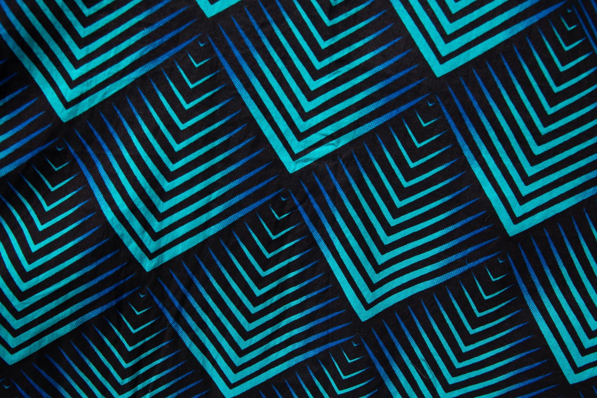 Close up display of black, blue and aqua print dress
