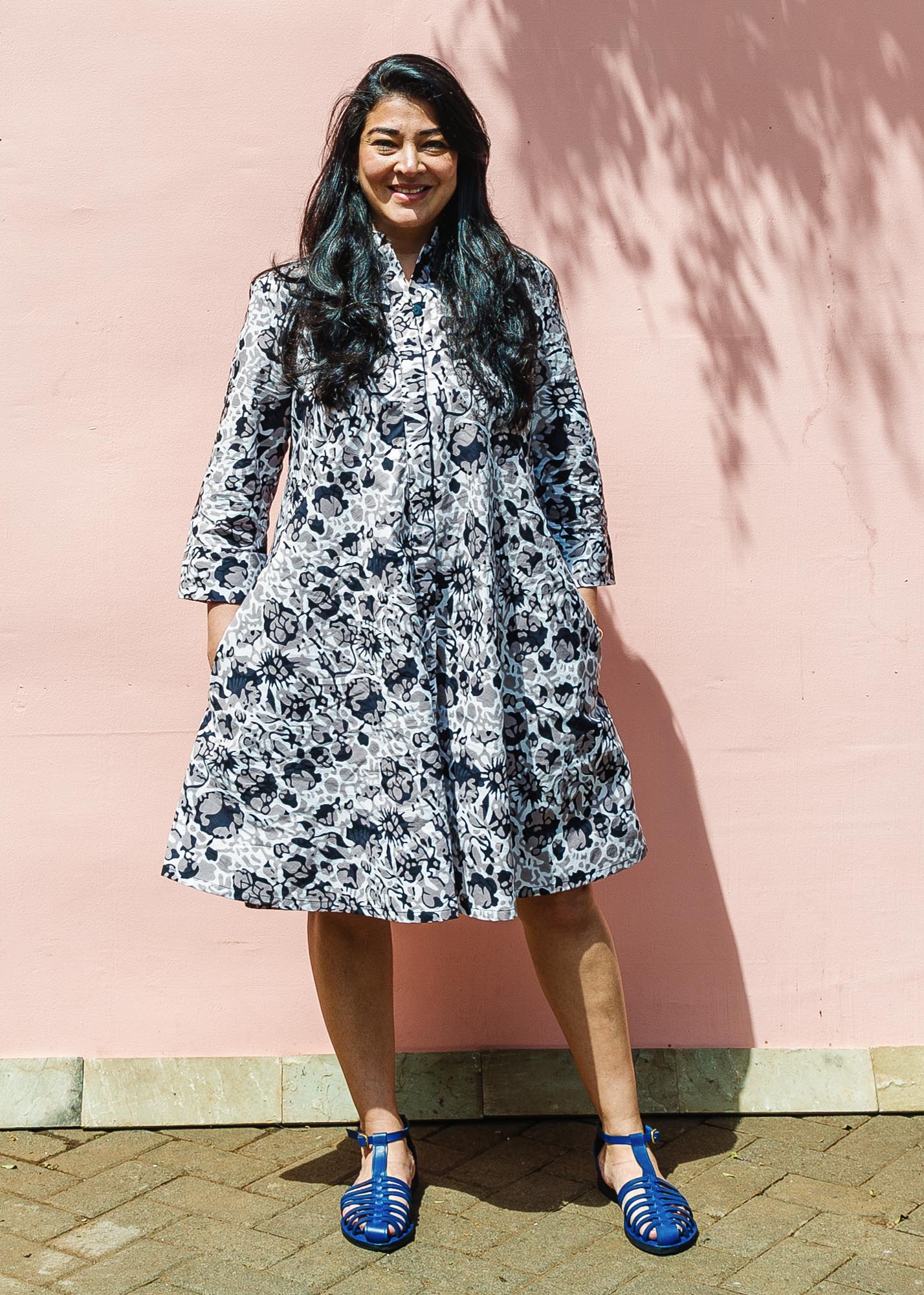 The model is wearing black, off white, gray and dark gray abstract print dress