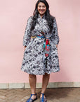 The model is wearing black, off white, gray and dark gray abstract print dress