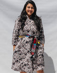 The model is wearing black, off white, gray and dark gray abstract print dress