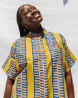 The model is wearing olive-yellow, blue, orange and white geometric printed shirt