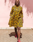 The model is wearing black, yellow print dress