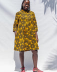 The model is wearing black, yellow print dress