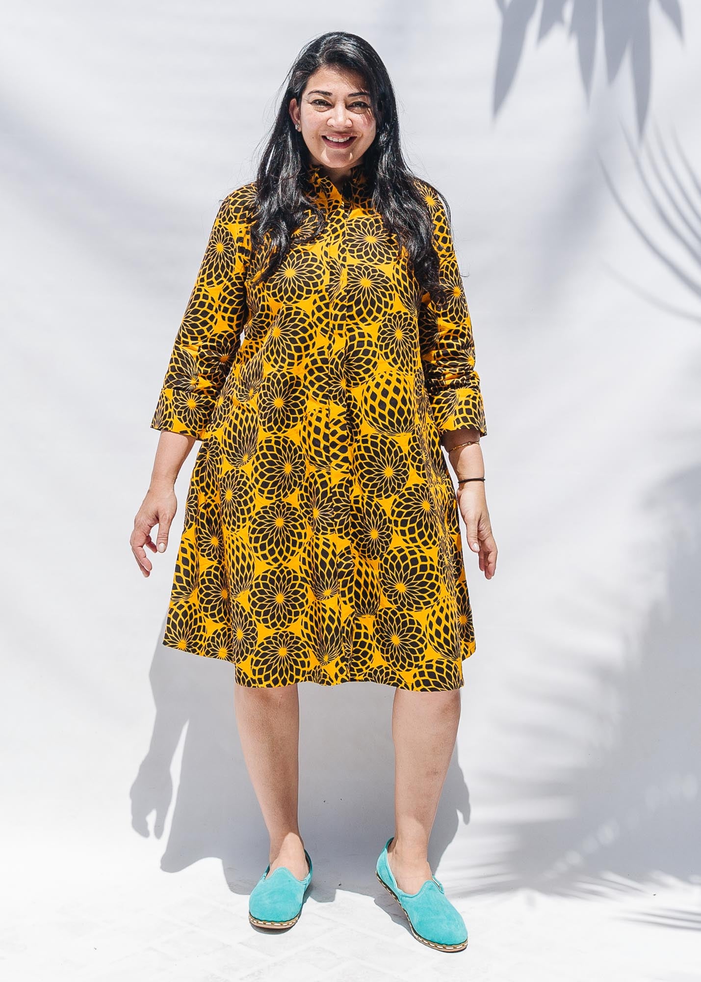 The model is wearing black, yellow print dress