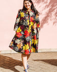 The model is wearing black, white, red, yellow, peach floral print dress
