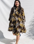 The model is wearing black, brown, yellow, beige print dress