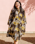 The model is wearing black, brown, yellow, beige print dress