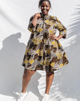 The model is wearing black, brown, yellow, beige print dress