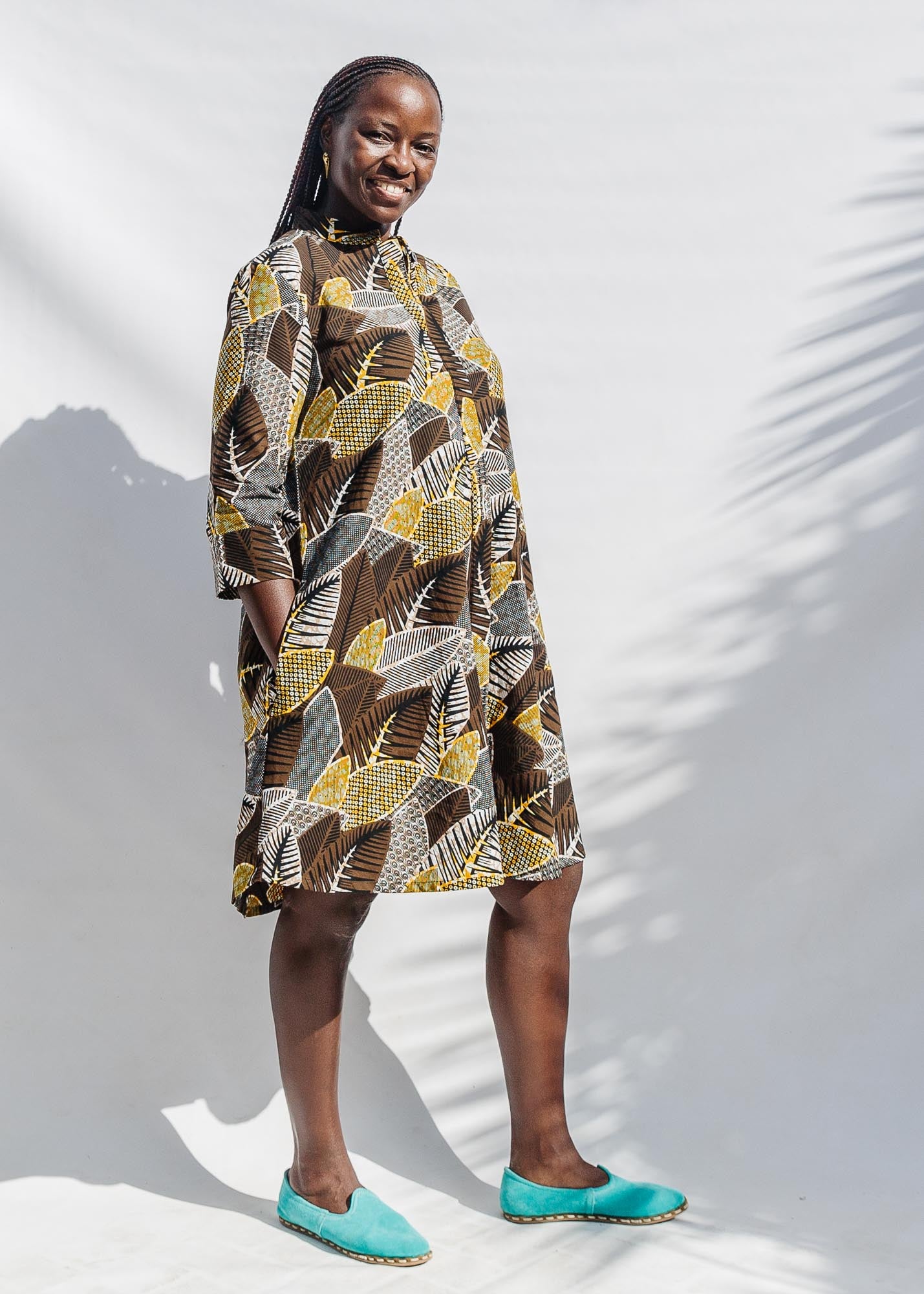 The model is wearing black, brown, yellow, beige print dress