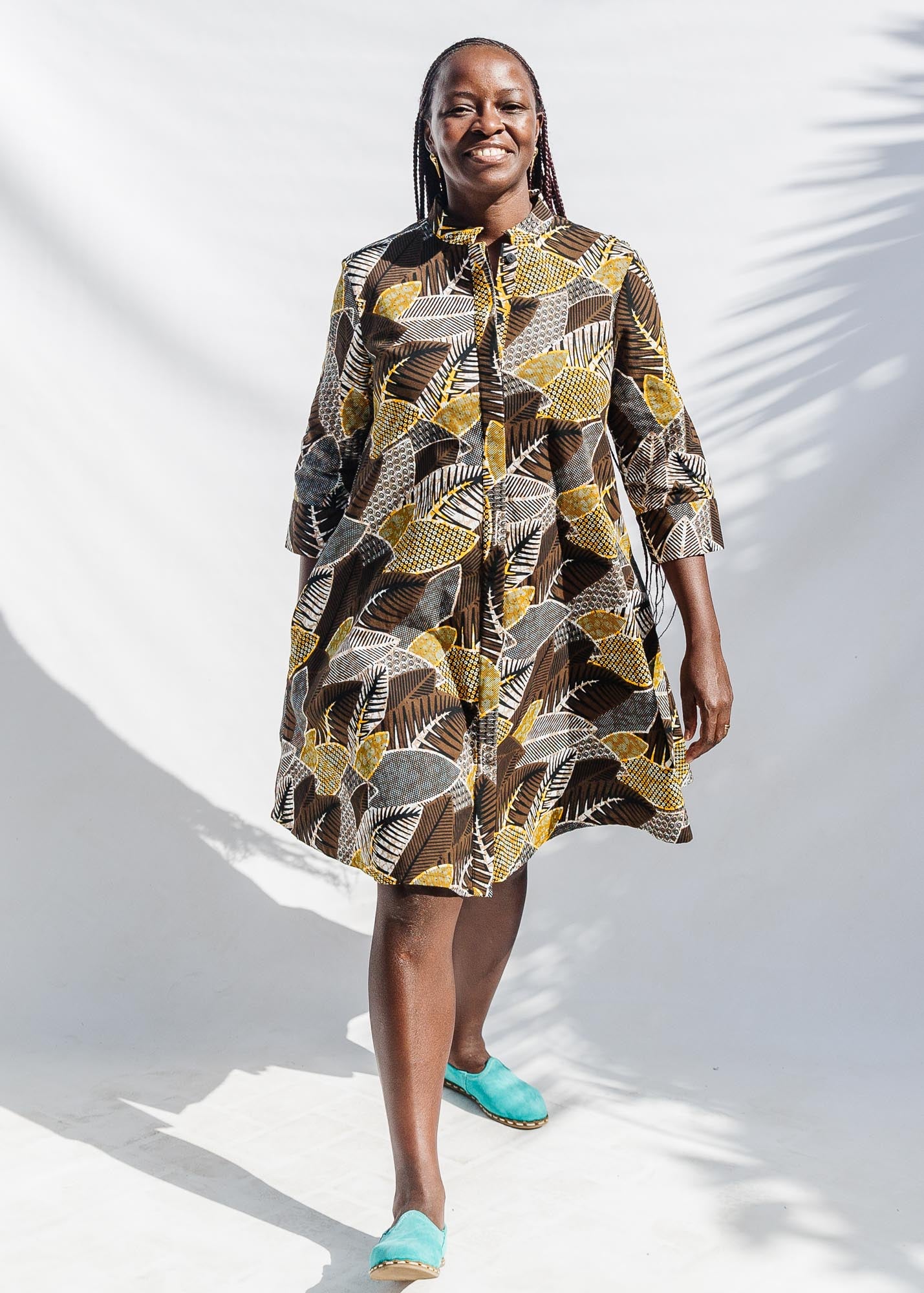 The model is wearing black, brown, yellow, beige print dress