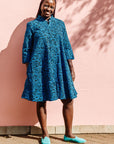 The model is wearing blue and black print dress