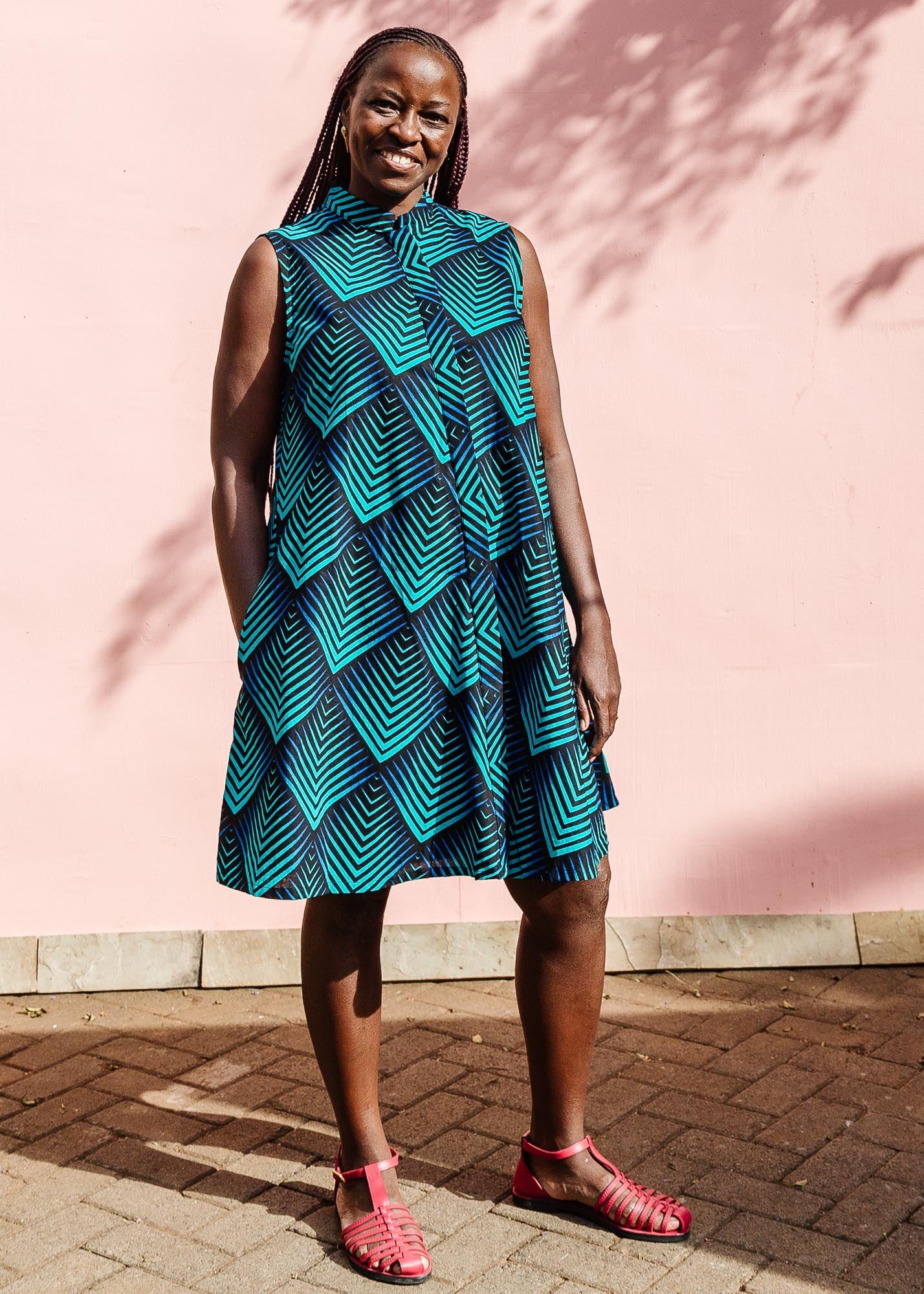 The model is wearing black, blue and aqua print dress