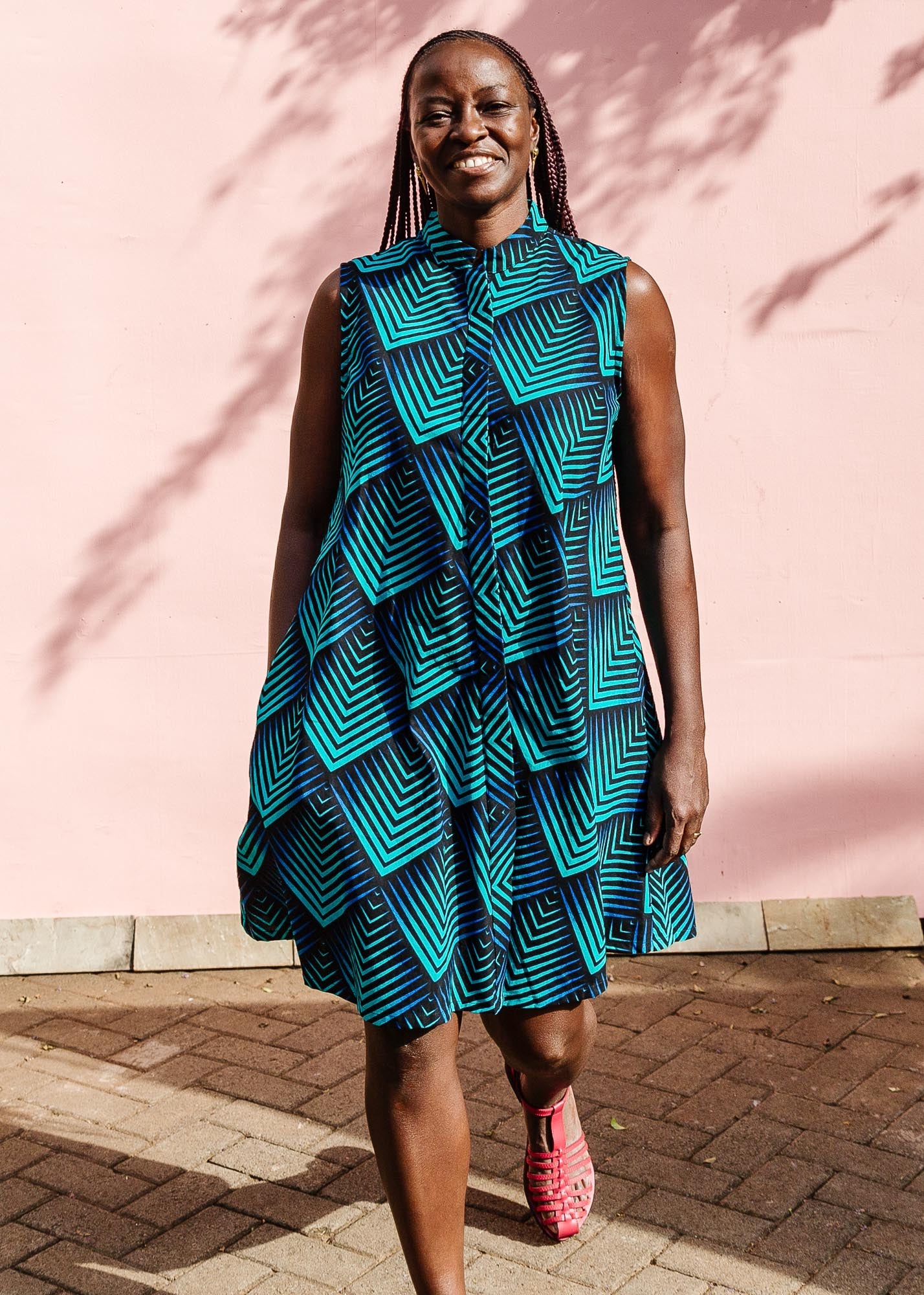 The model is wearing black, blue and aqua print dress