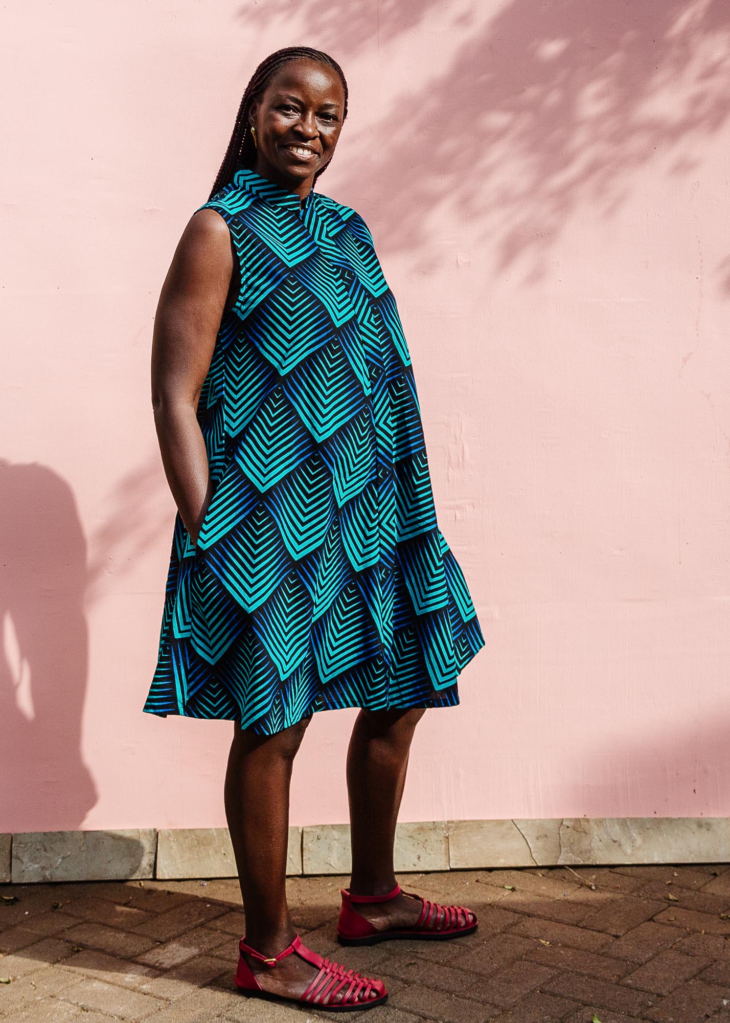 The model is wearing black, blue and aqua print dress