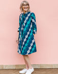Model wearing circular grid print dress, with hues of blue.