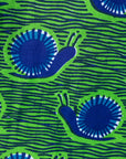 Close up display of sleeveless dress with green and blue snail print.