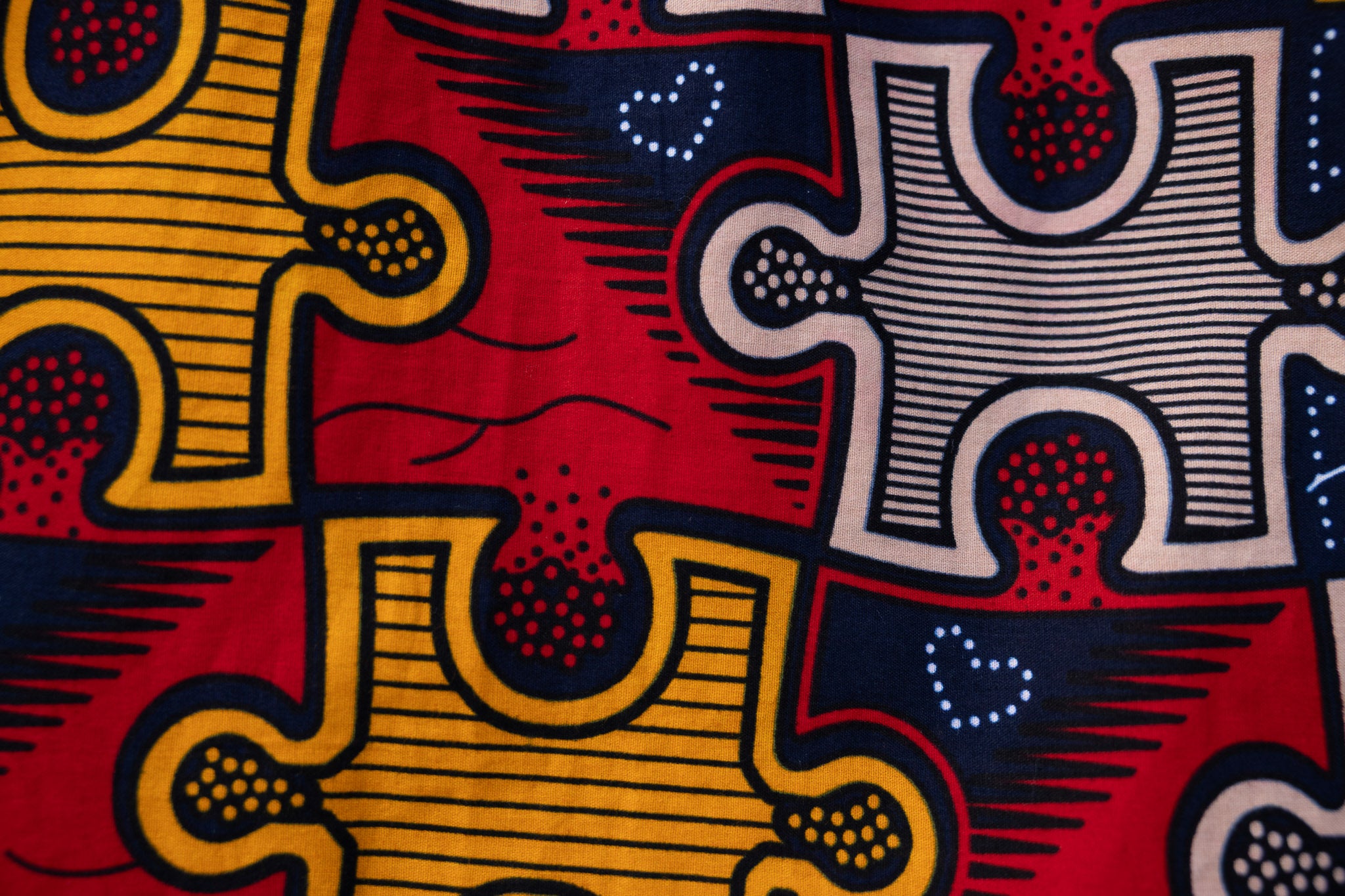 Close up display of multicolored puzzle print shirt, fabric.