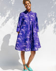 Model wearing purple dress with octopus print.