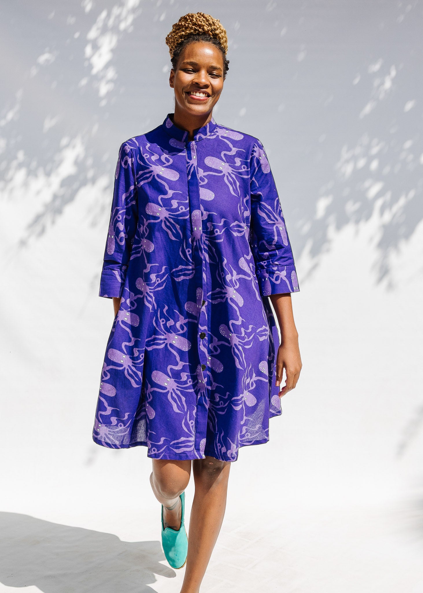 Model wearing purple dress with octopus print.