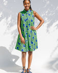 Model wearing sleeveless dress with green and blue snail print.