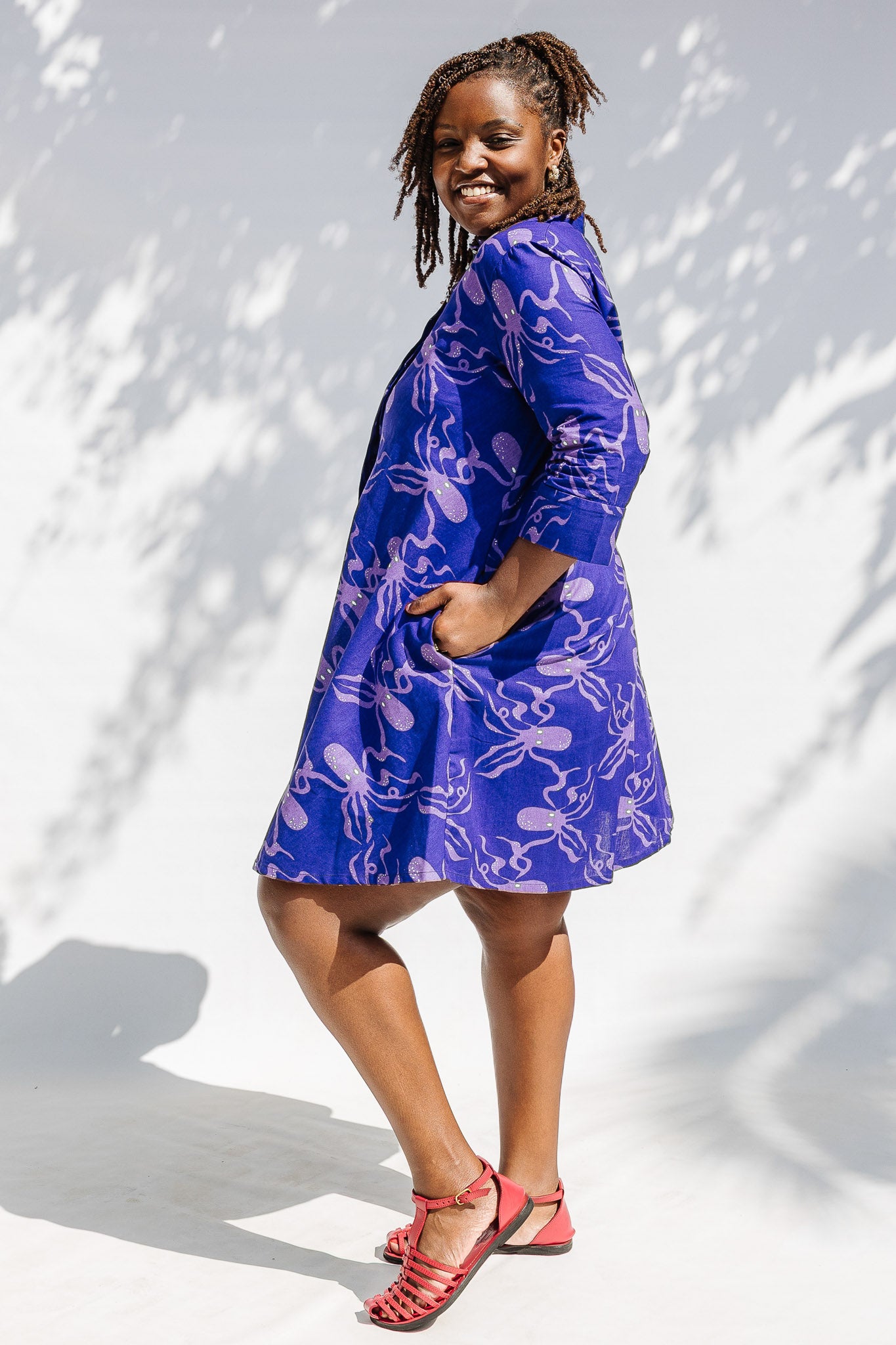 Model wearing purple dress with octopus print.
