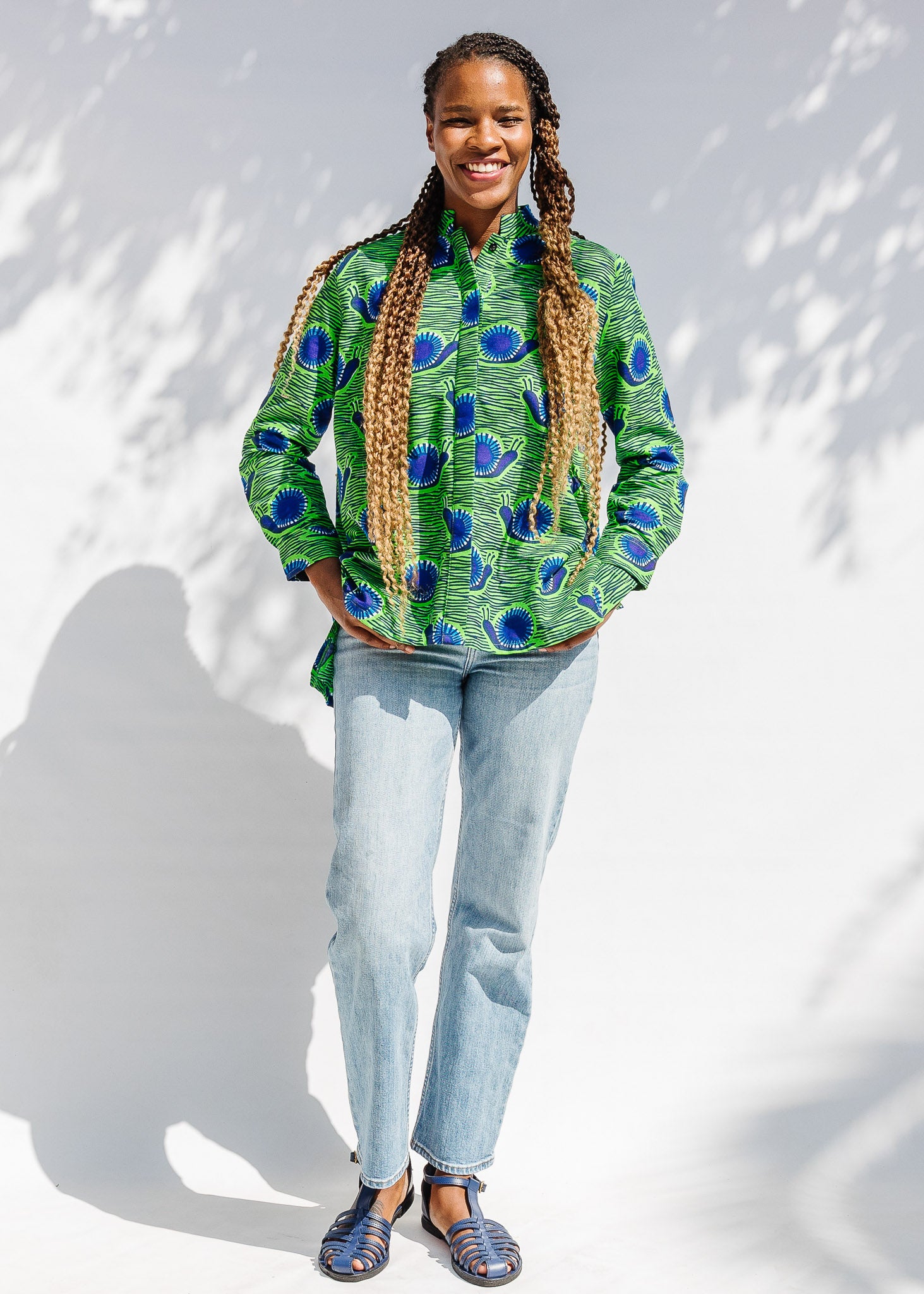 Model wearing green and blue snail print, long sleeved shirt.