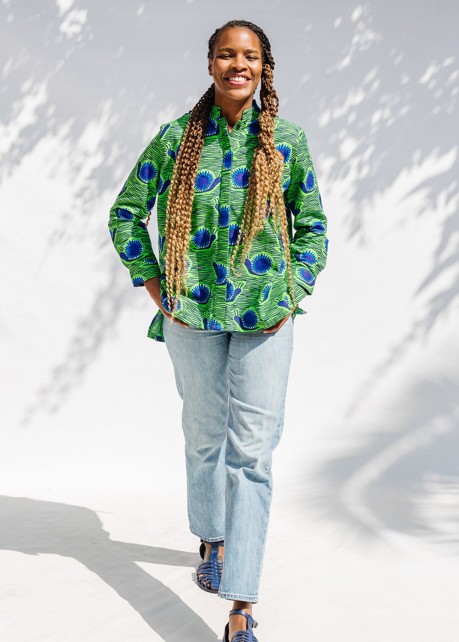 Model wearing green and blue snail print, long sleeved shirt.