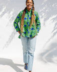Model wearing green and blue snail print, long sleeved shirt.