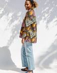 Model wearing pink and orange long sleeved blouse.