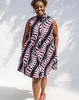 Model wearing black and pink sleeveless print dress.