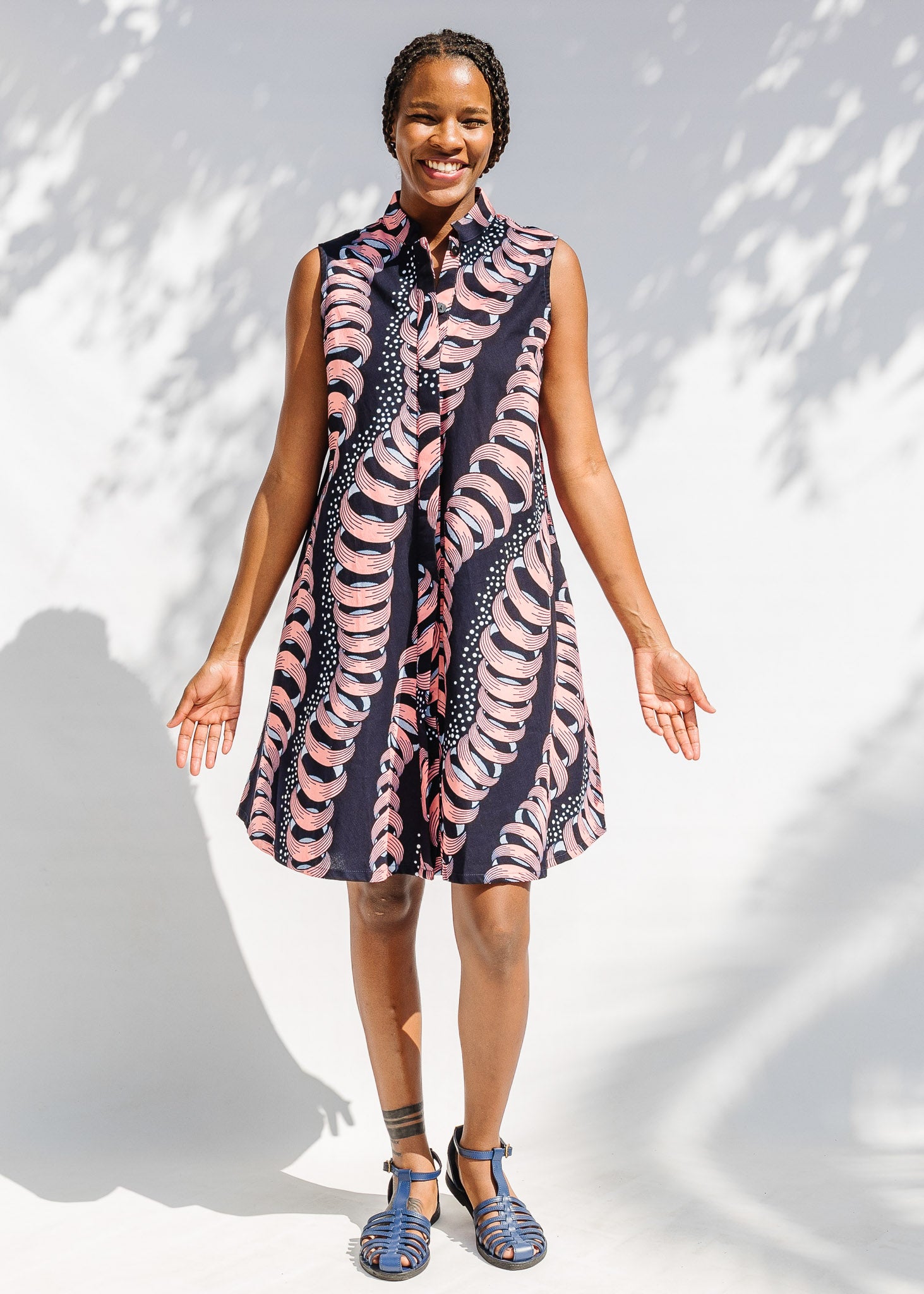 Model wearing black and pink sleeveless print dress.