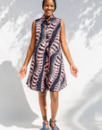 Model wearing black and pink sleeveless print dress.