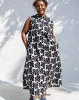Model wearing black and white floral print, sleeveless dress.