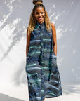 Model wearing black dress with aqua and navy abstract print.