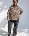 Model wearing black and beige abstract print blouse.
