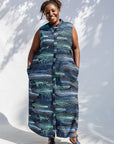 Model wearing black dress with aqua and navy abstract print.