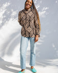 Model wearing black and beige abstract print blouse.