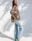 Model wearing black and beige abstract print blouse.