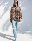 Model wearing black and beige abstract print blouse.