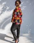 Model wearing multicolored puzzle print shirt.