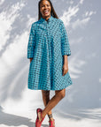 Model wearing blue and black squiggle print dress.